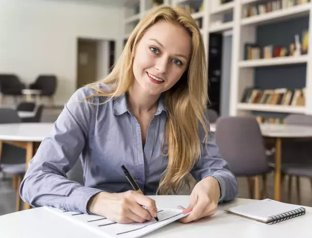 femme-blonde-écrit-sur-une-table